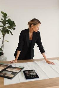 Phụ nữ doanh nhân mặc suit đen thanh lịch phát biểu tại sự kiện, thể hiện hình ảnh phụ nữ thành đạt và chuyên nghiệp