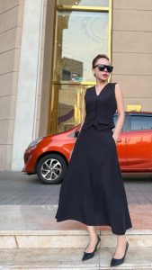 Phụ nữ thành đạt mặc đầm đen dài thanh lịch, phong thái tự tin và chuyên nghiệp ngoài phố