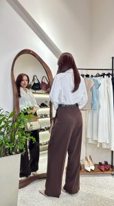 Phụ nữ phối đồ thanh lịch với áo sơ mi trắng và quần ống rộng nâu phong cách tối giản tại Thắm Đặng