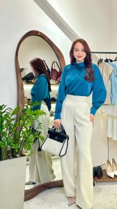 Phụ nữ mặc áo xanh navy và quần trắng theo phong cách quiet luxury, thanh lịch và tối giản