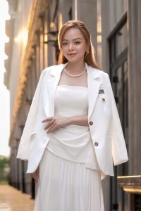 Phụ nữ thanh lịch mặc blazer trắng trắng tối giản tại cửa hàng Thắm Đặng, phong thái chuyên nghiệp và tinh tế