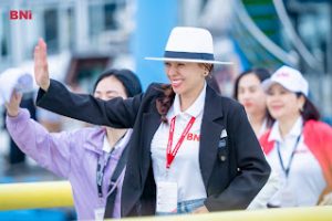 Phụ nữ doanh nhân mặc blazer đen và mũ trắng tham gia sự kiện BNI, phong thái tự tin và bản lĩnh